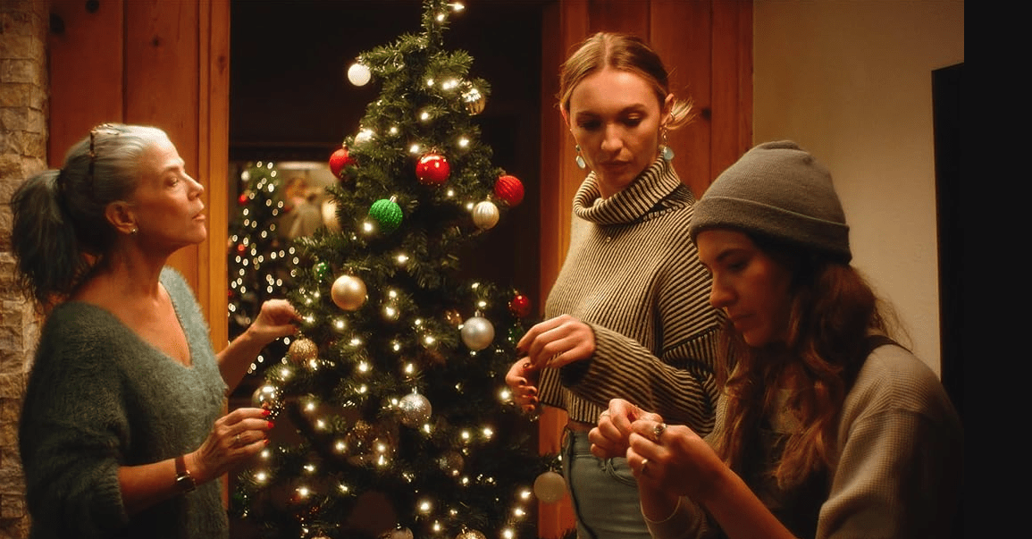 people decorating a christmas tree