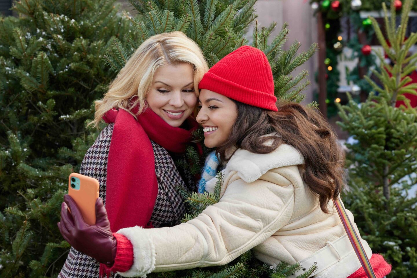 people taking a selfie while by a christmas tree