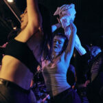 Image of attendees at BP events, raising arms in the air, dancing and having a good time.