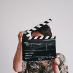 a woman holding a clapper over her face