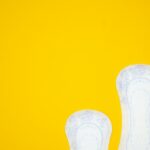 a pair of white shoes on a yellow background