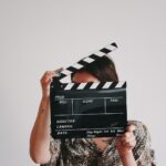 a woman holding a clapper over her face