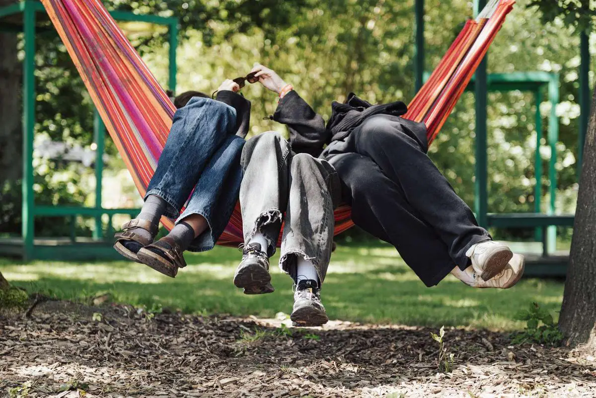 three people sitting in a hammock