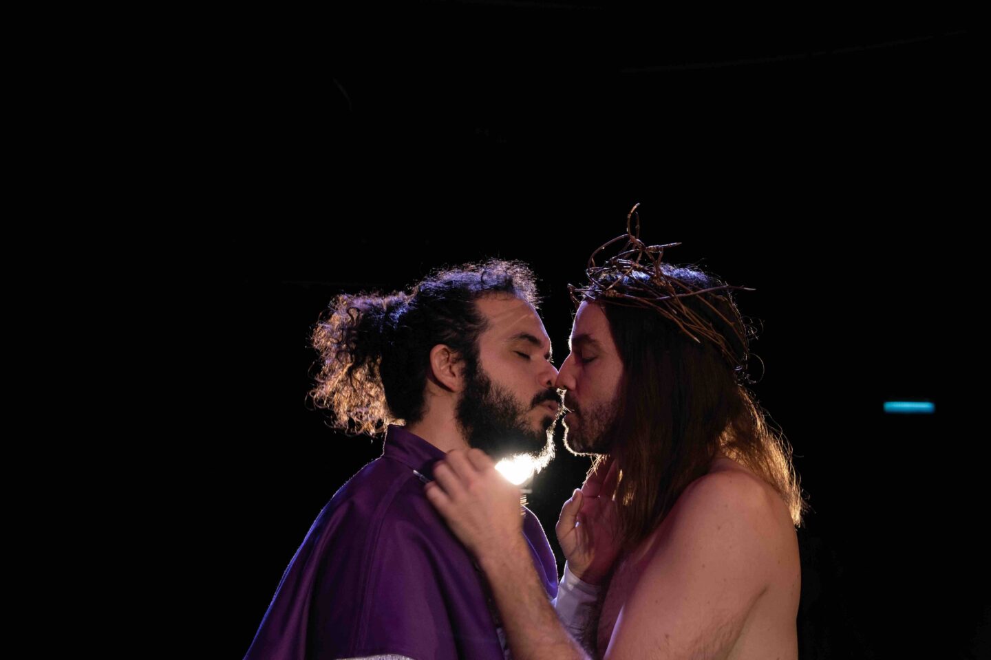 two men leaning in to kiss, one looks like Jesus.