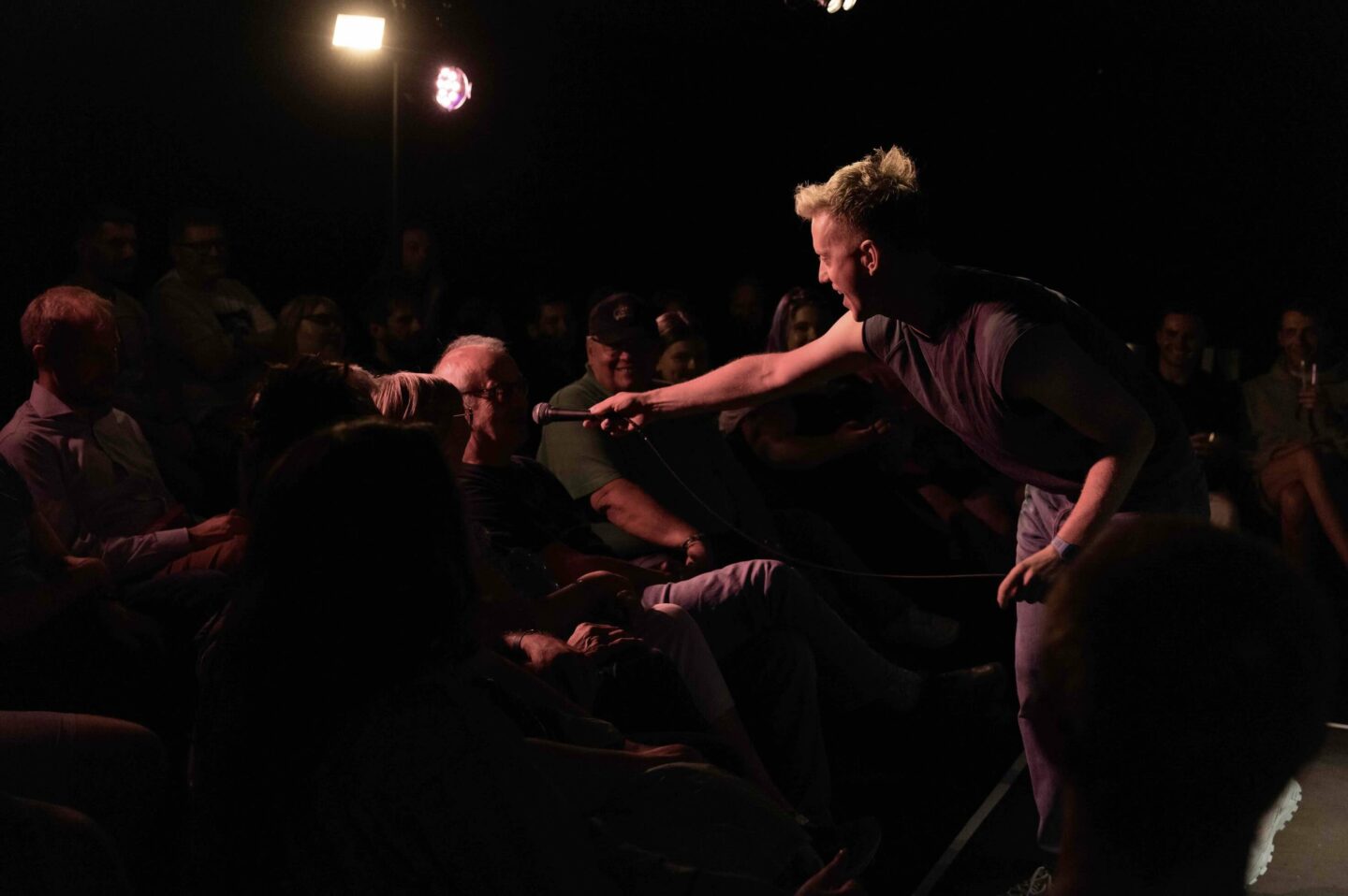 a man holding a mic to the crowd