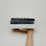 person holding pile of books