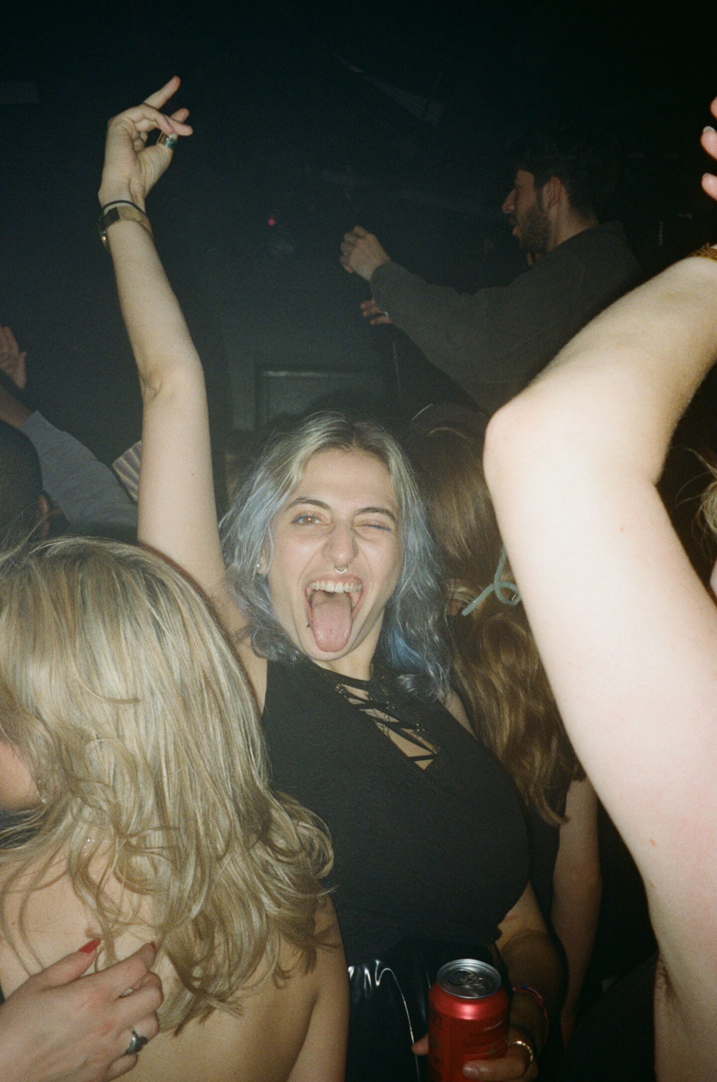 a person with their hand in the air with blue hair