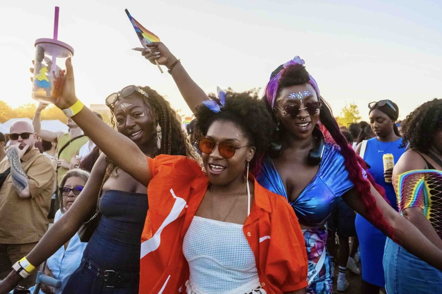 Women pointing in to the air at a festival