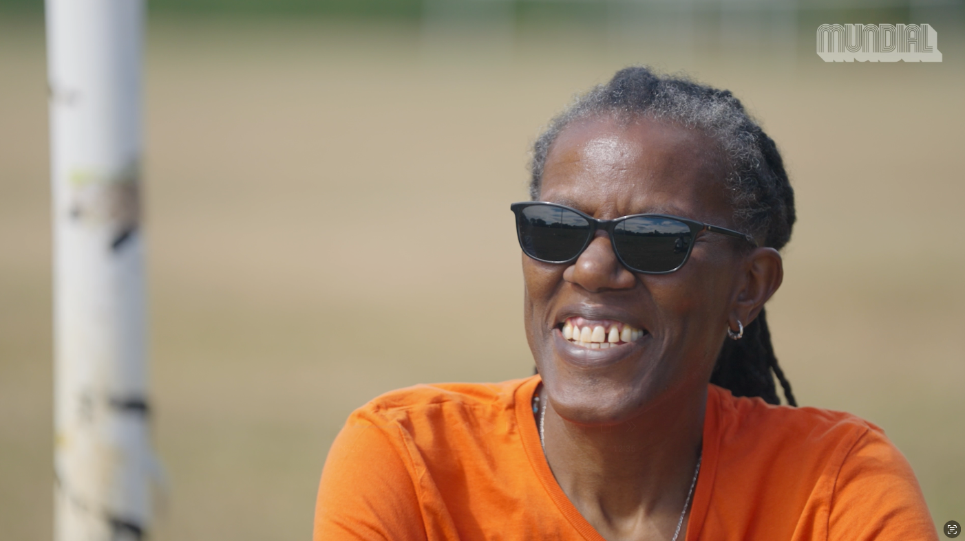 a woman wearing sun glasses smiling at the camera