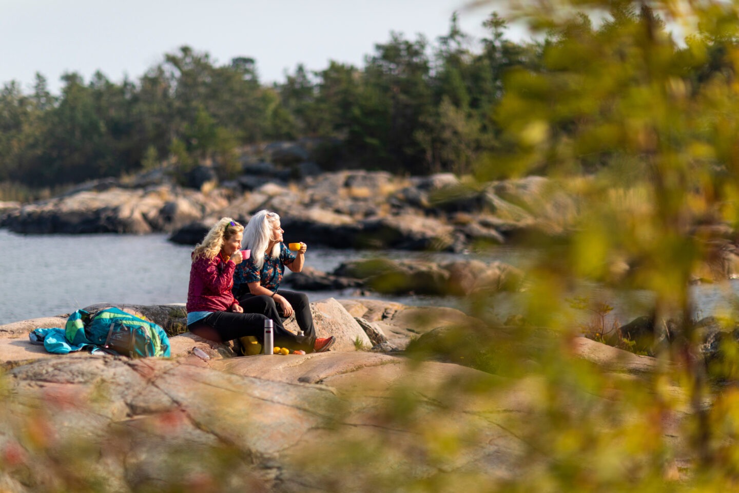 two women sat by a lake