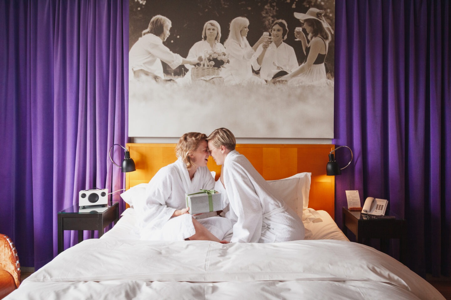 two women about to kiss in a bed