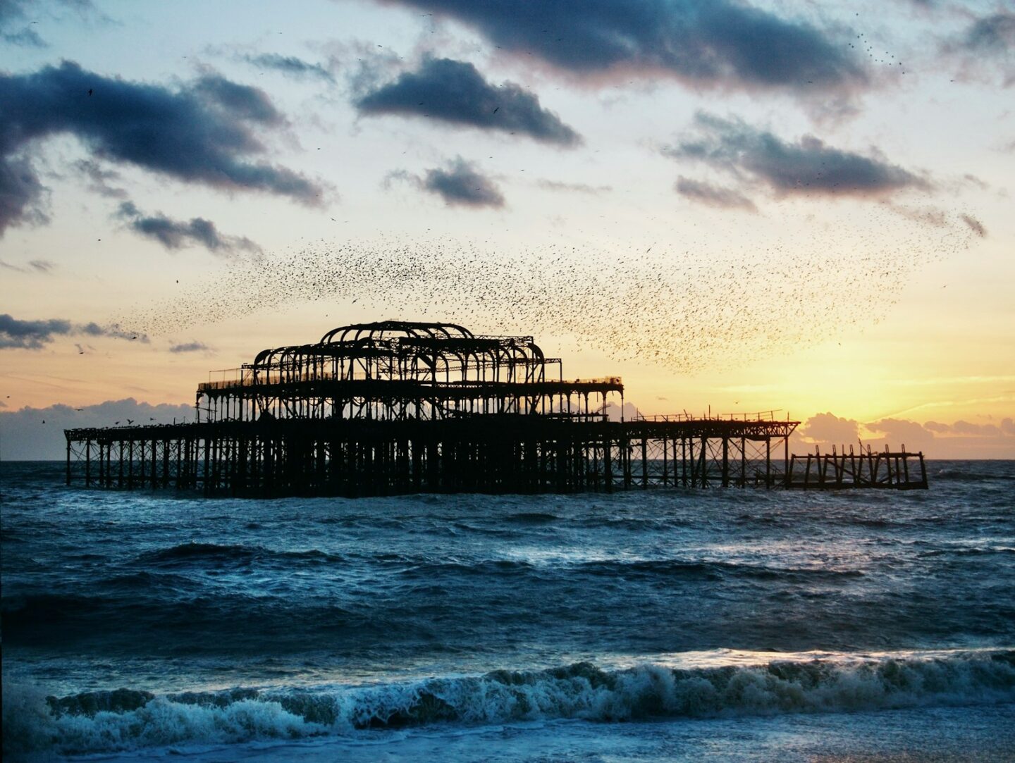 a large structure sitting on top of a beach next to the ocean