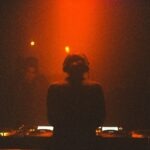 a woman standing in front of a dj set