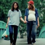 Two women holding hands one is pregnant