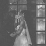 Couple kissing in front of a window